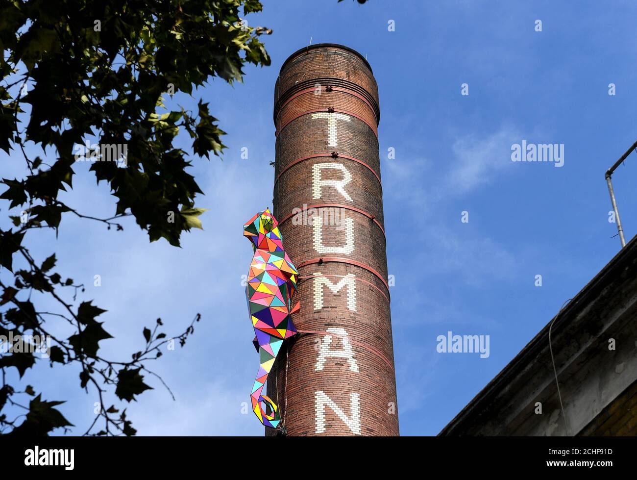 REDAKTIONELLE NUTZUNG AUF dem Schornstein der Old Truman Brewery in East London ist nur eine acht Meter lange Skulptur eines Chameleons installiert, wo es bis zum 1. September zur Eröffnung des neuen nhow Hotels in Shoreditch zu sehen sein wird. Stockfoto