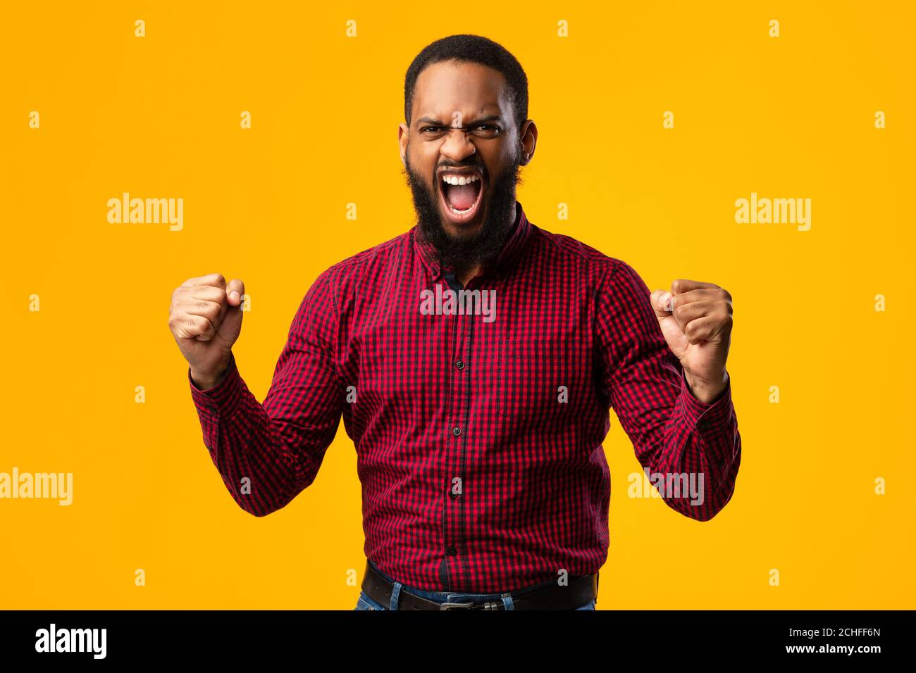 Portrait eines Afro-Mannes, der mit erhobenen Fäusten schreit Stockfoto