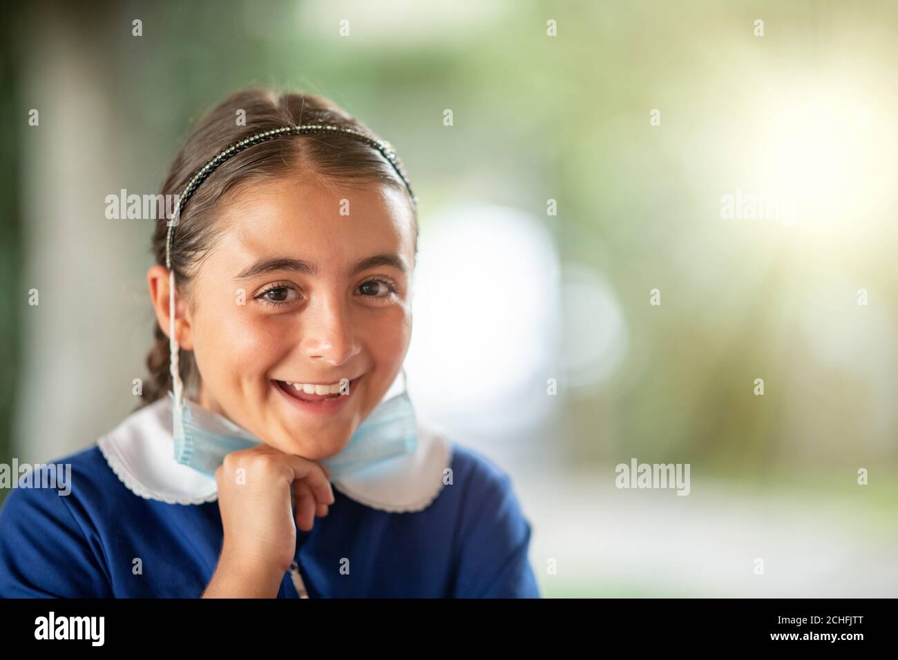 Gefühle von Glück und Traurigkeit angesichts eines jungen Mädchens, das nach einer Pandemie in die Schule zurückkehrt. Stockfoto