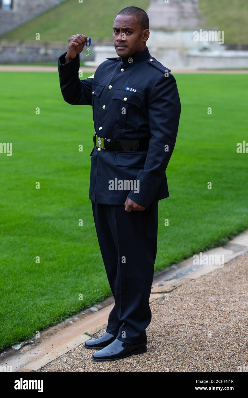Korporal Saimone Qasenivalu, Royal Tank Regiment, mit seiner Queen's Gallantry Medal, verliehen von Queen Elizabeth II bei einer Investiturzeremonie in Windsor Castle, Berkshire. Stockfoto