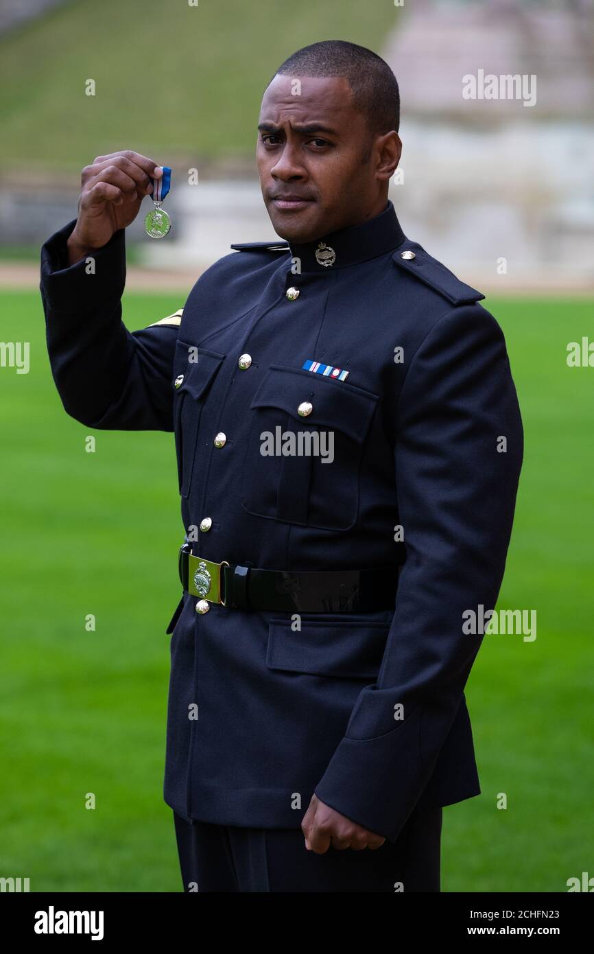 Korporal Saimone Qasenivalu, Royal Tank Regiment, mit seiner Queen's Gallantry Medal, verliehen von Queen Elizabeth II bei einer Investiturzeremonie in Windsor Castle, Berkshire. Stockfoto