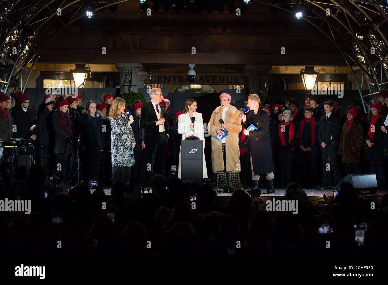 REDAKTIONELLE VERWENDUNG NUR Paul Feig (zweiter links) Emilia Clarke (Mitte) und Dame Emma Thompson (Mitte rechts), aus dem neuen Film ???Last Christmas???, schalten Sie die Covent Garden Weihnachtsbeleuchtung in London ein. Stockfoto