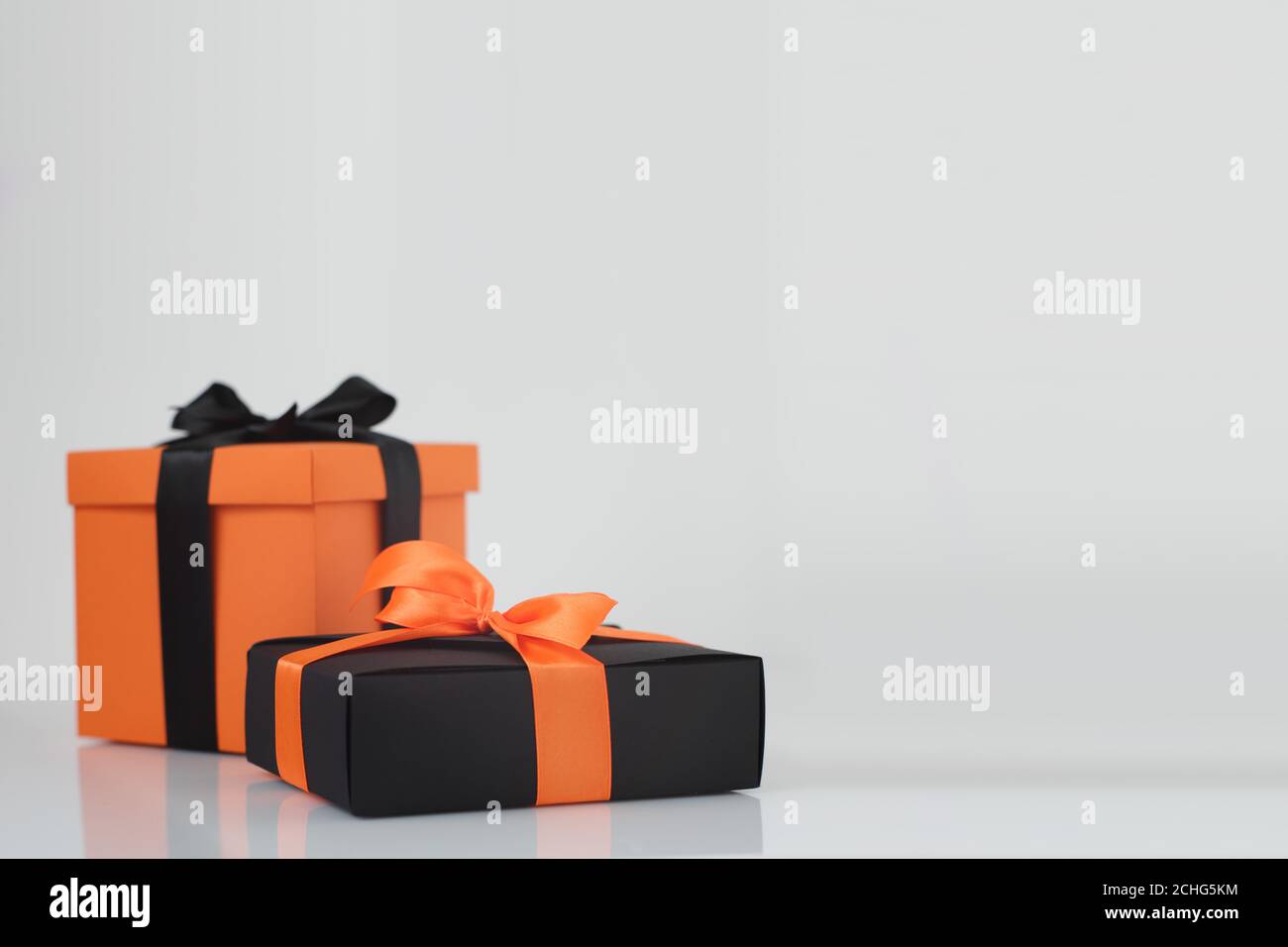 Dekoriert schwarz und orange Farbe halloween Geschenkboxen auf grauem Hintergrund mit Kopieplatz für Text, Ecke Komposition Stockfoto