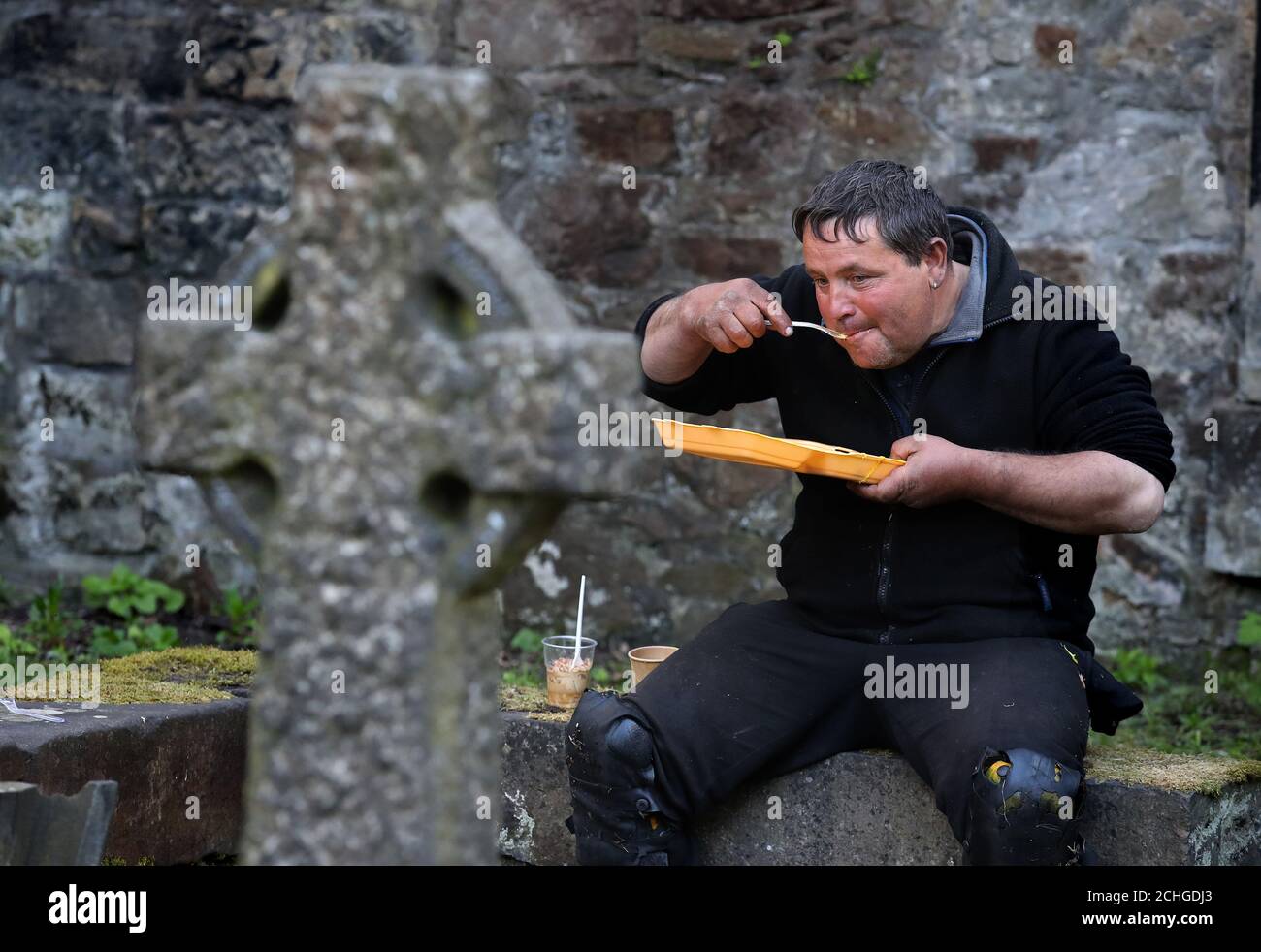 Ein Benutzer (Name nicht gegeben) des Dienstes angeboten durch die Step to Hope Wohltätigkeitsorganisation isst sein Essen auf dem Gelände der Pfarrkirche St. Cuthbert in Edinburgh. Die Wohltätigkeitsorganisation in Edinburgh, die Mahlzeiten an Obdachlose verteilt, normalerweise werden Mahlzeiten in der Kirche serviert, aber aufgrund von Einschränkungen werden diese außerhalb an Obdachlose übergeben, da das Vereinigte Königreich weiterhin in der Sperre bleibt, um die Ausbreitung des Coronavirus einzudämmen. Stockfoto