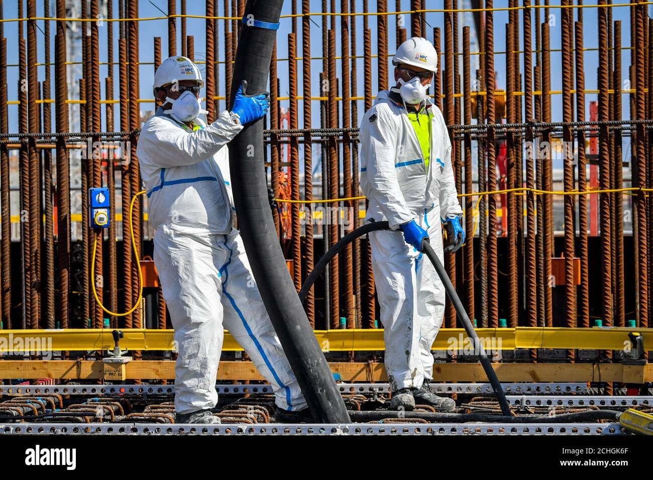 MONTAG, DEN 0001. JUNI 01 gesperrt Betongießer-Teams tragen zusätzliche PSA, da sie eng als Team zusammenarbeiten müssen und können nicht sozial Abstand während der Fertigstellung einer Betongießen in die Basis der Einheit 2 Kernreaktor im Hinkley Point C Kernkraftwerk in der Nähe von Bridgwater, Somerset, Europas größte Baustelle. Stockfoto