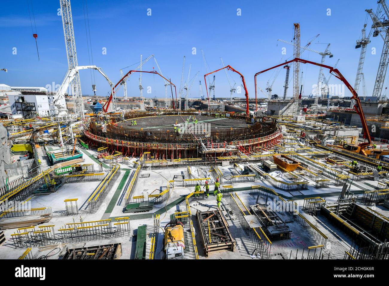 Bauarbeiter und riesige Betonpumparme füllen die Stahlbasis des Kernreaktors Block 2 im Kernkraftwerk Hinkley Point C in der Nähe von Bridgwater, Somerset, Europas größter Baustelle. Stockfoto