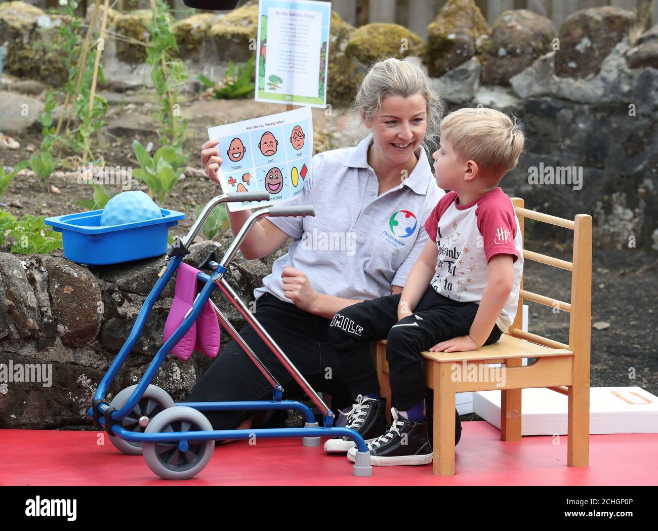 Die Physiotherapeutin Leah Honohan und Oliver Cunningham während einer gemeinsamen Theraplay-Sitzung im Therapiebereich außerhalb des Craighalbert Center. Im Scottish Centre for Children with Motor Impairments, Craighalbert Centre, Cumbernauld, wurden Coronavirus-Anpassungen installiert, da Schottland die Maßnahmen zur Sperrung des Coronavirus schrittweise aufhebt. Stockfoto