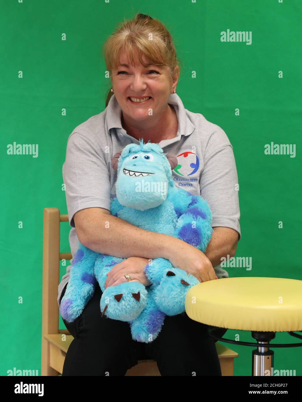 Klassenlehrerin Margaret Poli hält das Maskottchen Sully im Zentrum, während sie an einer Geschichtenmassage im Craighalbert Center per Zoom teilnehmen. Diese Sitzungen finden statt, um Kindern, die sich abschirmen, Blended Learning zu bieten. Im Scottish Centre for Children with Motor Impairments, Craighalbert Centre, Cumbernauld, wurden Coronavirus-Anpassungen installiert, da Schottland die Maßnahmen zur Sperrung des Coronavirus schrittweise aufhebt. Stockfoto