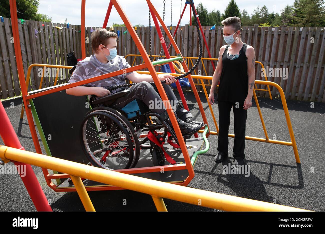 Am 0001. Juni 22 ist Gregor Marshall mit seiner Mutter Karen als Gregor auf der Rollstuhlschaukel im aussen Therapiebereich des Craighalbert Centers unterwegs. Coronavirus-Adaptionen wurden im Scottish Centre for Children with Motor Impairments, Craighalbert Centre, Cumbernauld, installiert, da Schottland die Maßnahmen zur Blockierung des Coronavirus schrittweise aufhebt. Stockfoto