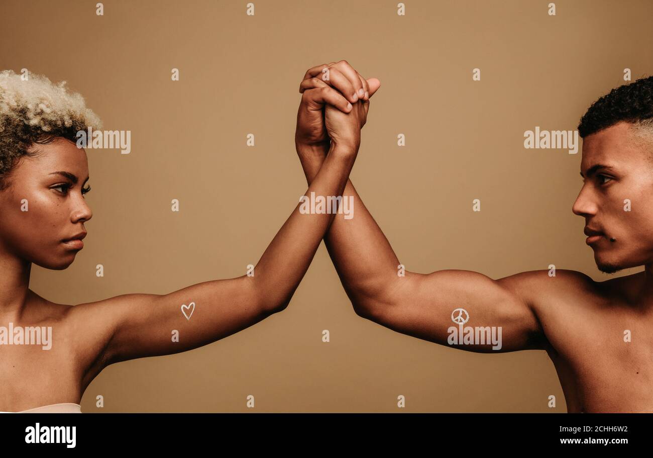 afroamerikanisches Paar, das zusammen die Hände in Einheit hält. Zugeschnittenes Schuss von Paar halten Hände mit Symbolen der schwarzen Leben Materie auf b gemalt Stockfoto