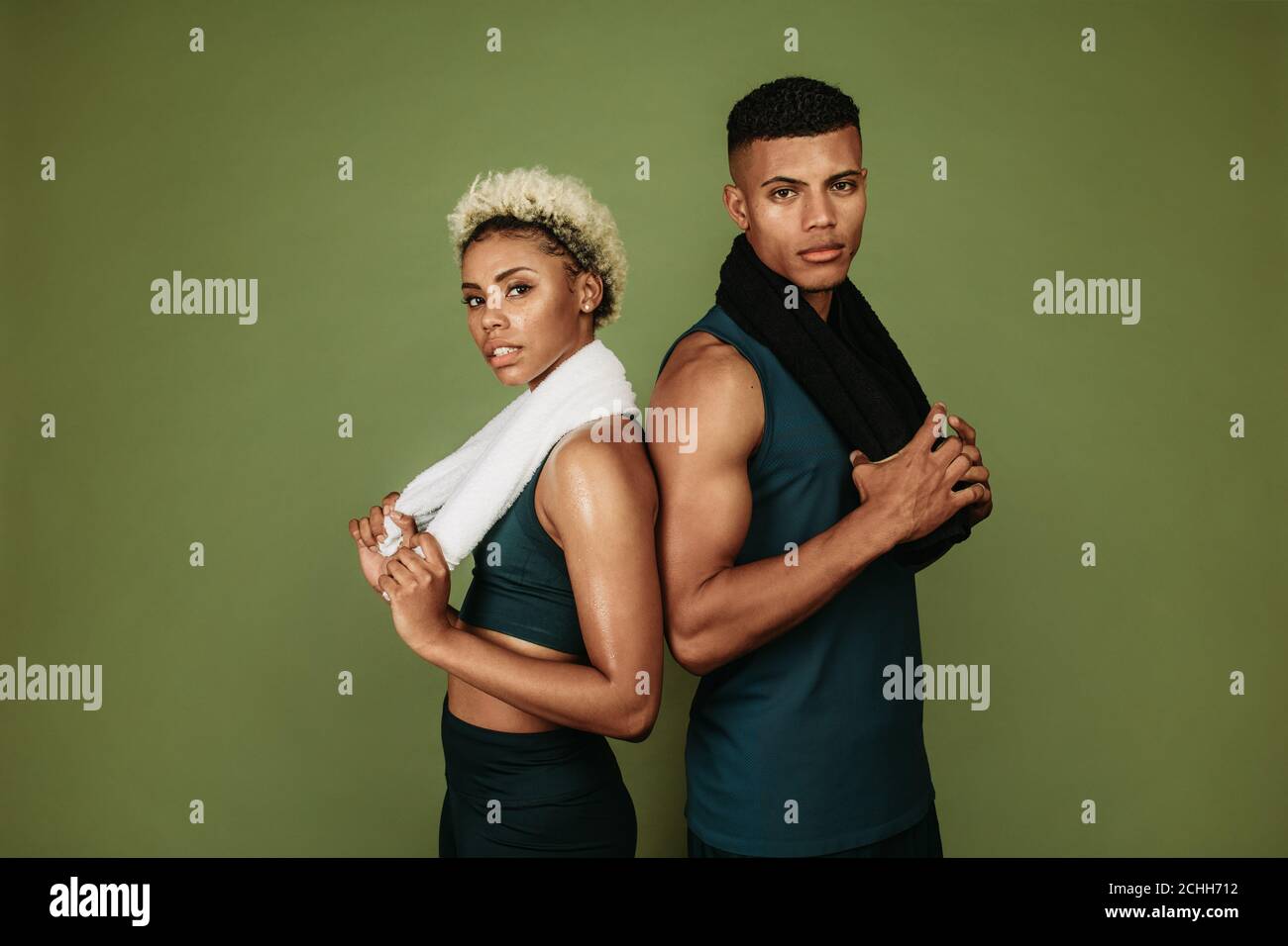 afroamerikanischer Mann und Frau in Fitnesskleidung stehen nach dem Training zusammen. Fitnesspaar, das sich nach dem Training entspannt und Handtücher hält. Stockfoto