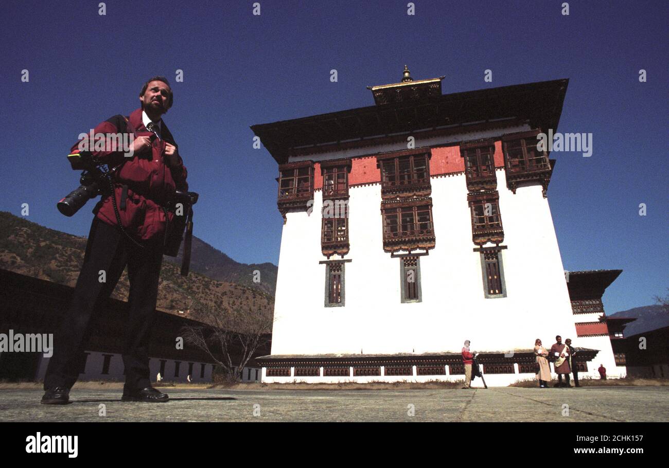 DER PA-MITARBEITER-FOTOGRAF JOHN STILLWELL MACHT EINE PAUSE, WÄHREND ER DEN BESUCH DES PRINZEN VON WALES IN PARO, BHUTAN, MITMACHT. Stockfoto