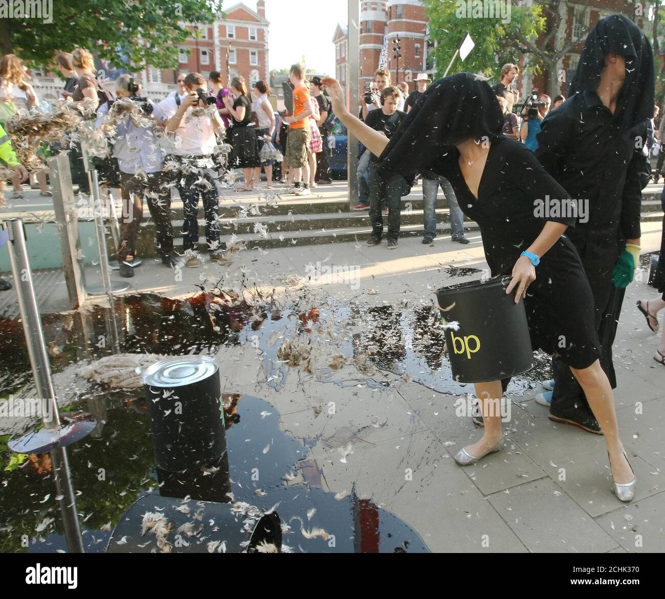 Demonstranten schütten Öl und Federn vor den Eingang der Tate Britain in Pimlico, im Zentrum von London, wo die Tate Britain Sommerparty veranstaltet wird, als Teil eines Protests gegen BP-Sponsoring der Künste Stockfoto