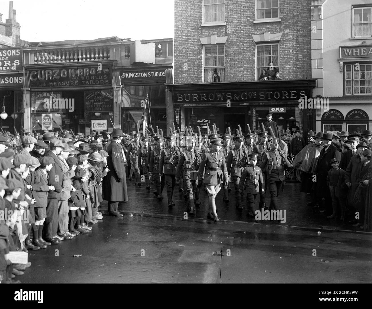 Mit ihrem Maskottchen, einem kleinen französischen Jungen, der an ihrer Spitze marschiert, werden das 9. Bataillon, East Surrey Regiment, zu Hause willkommen geheißen. Stockfoto