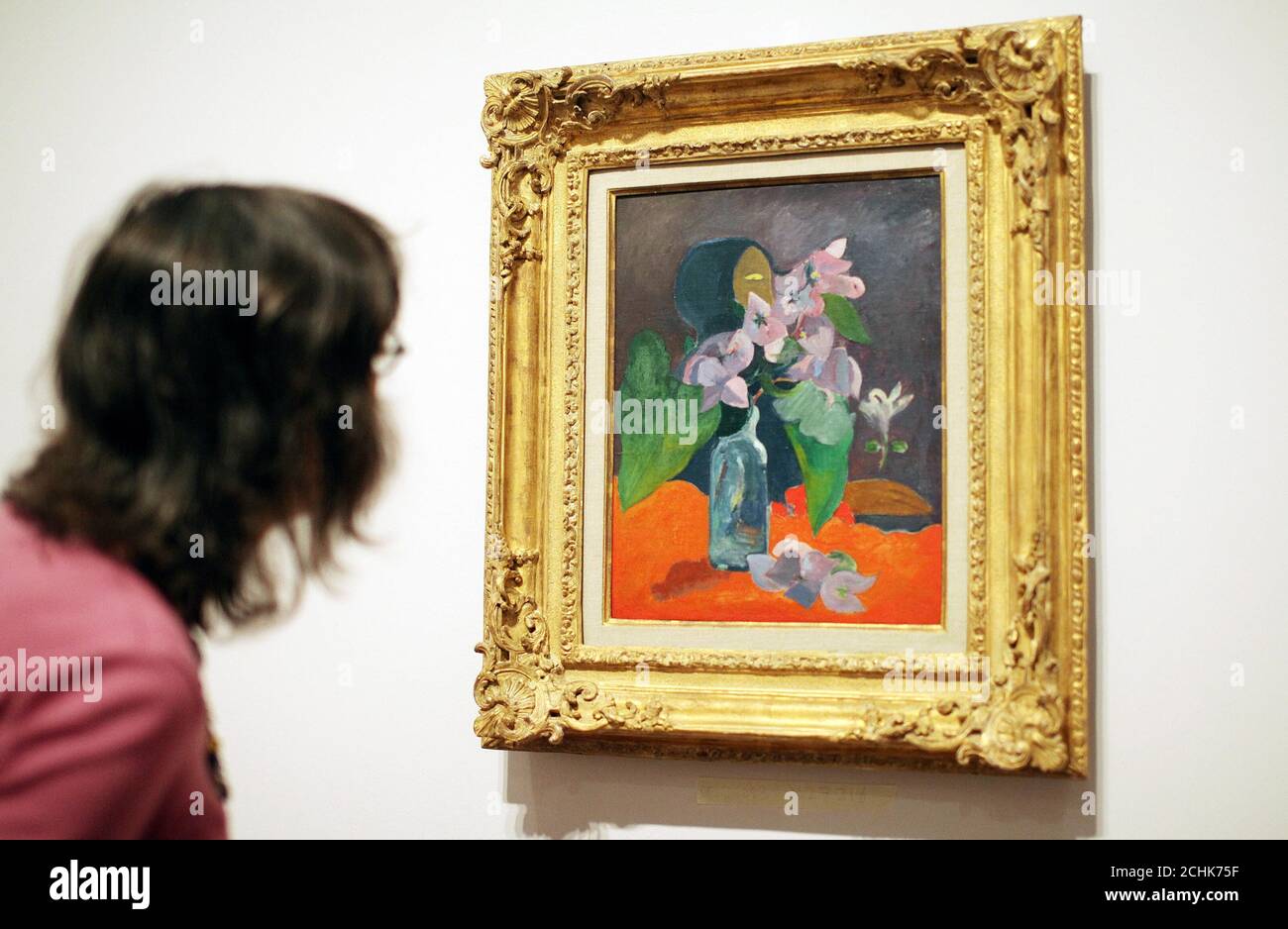 A Woman looks at 'Still Life with Flowers and Idol', 1892 at the Gauguin: Maker of Myth Exhibition at the Tate Modern, London. Stockfoto