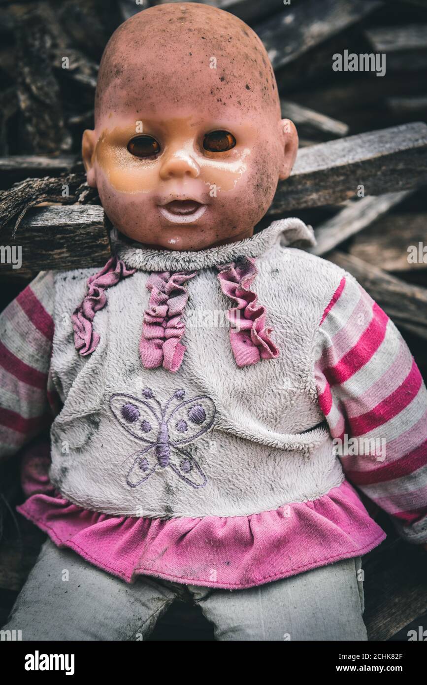 Ein Porträt von einem gruseligen alten Puppe, wie ein Baby aufgeworfen. Stockfoto