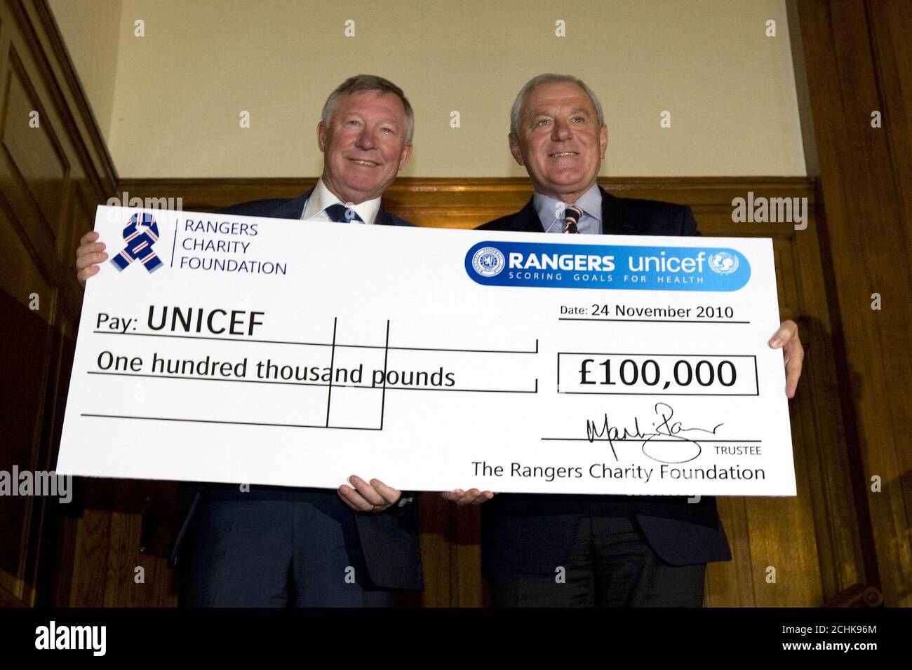 SONDERBILD - AUSSCHLIESSLICH ÜBER DIE PRESS ASSOCIATION ZUR VERWENDUNG DURCH NATIONALE UND REGIONALE ZEITUNGEN VERÖFFENTLICHT - NUR IN GROSSBRITANNIEN UND IRLAND. KEINE VERKÄUFE. Walter Smith, Manager der Rangers, und Sir Alex Ferguson, Manager von Manchester United, mit einem Scheck für UNICEF. Bilddatum: Mittwoch, 24. November 2010. Bildnachweis sollte lauten: Kirk O'Rourke/Rangers FC/PA. FÜR WEITERE RANGERS BILDER ODER LIZENZIERUNG DIESER BILDER FÜR ANDERE ZWECKE - BITTE KONTAKTIEREN SIE EMPICS - 0115 844 7447 ODER INFO@EMPICS.COM Stockfoto