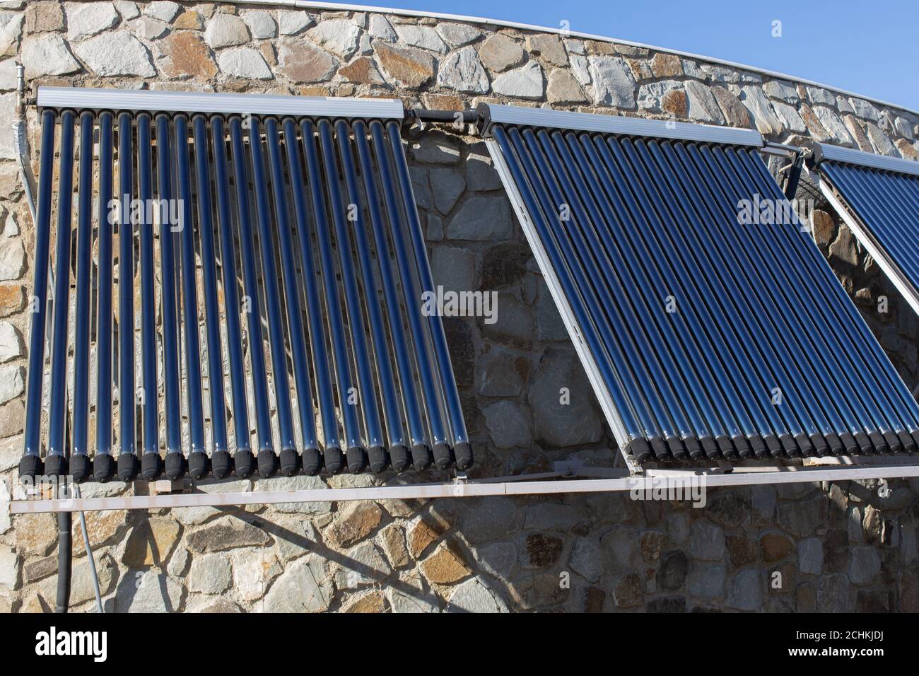 Solar-Wasser-Heizung an der Wand oder Dach des Hauses installiert. 3 Platten aus Glas koaxiale Rohre mit Wasser, um Wärme zu sammeln. Seitenansicht. Konzept-envir Stockfoto