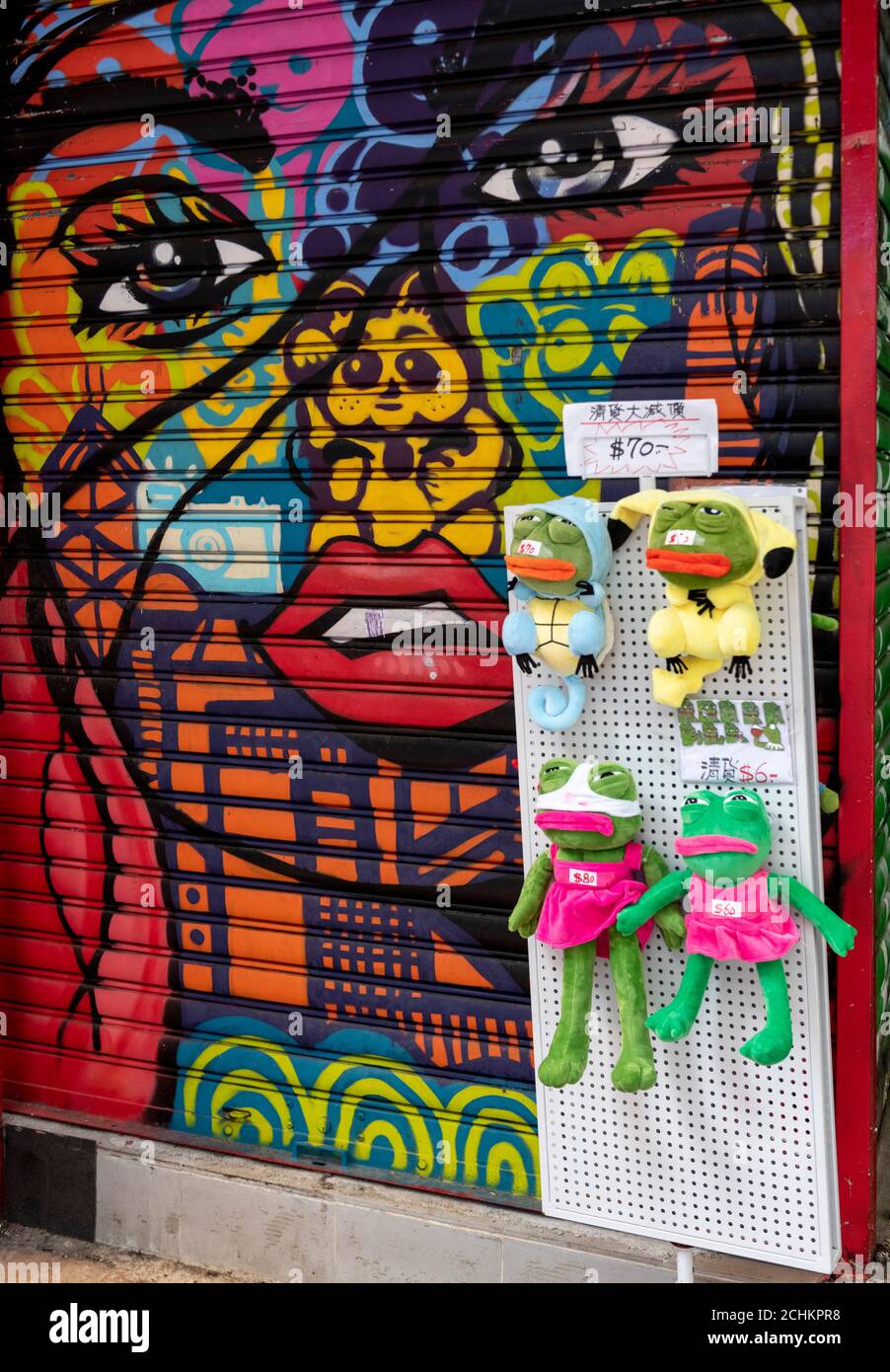 Hongkong, China: 11. September 2020. Street Art von Brit Szabotage aus Hove, UK auf einer Fensterläden in Causeway Bay Hongkong. Ein Straßenvender hängt Pepe den Frosch auf Stockfoto