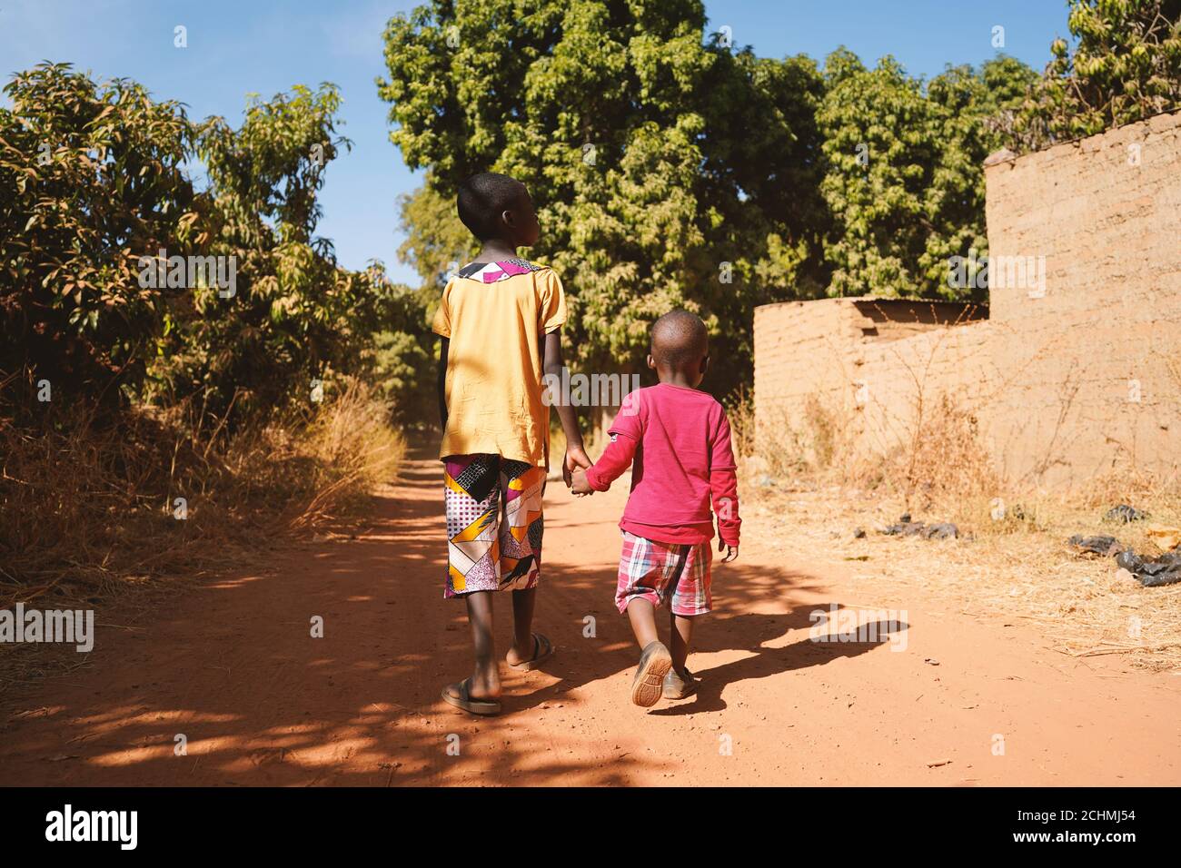 Zwei African Young Boys gehen zusammen in einem typischen Afrikaner Dorf Stockfoto