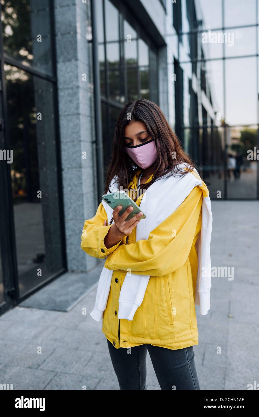 Junge Frau trägt Maske posiert auf der Straße. Stockfoto