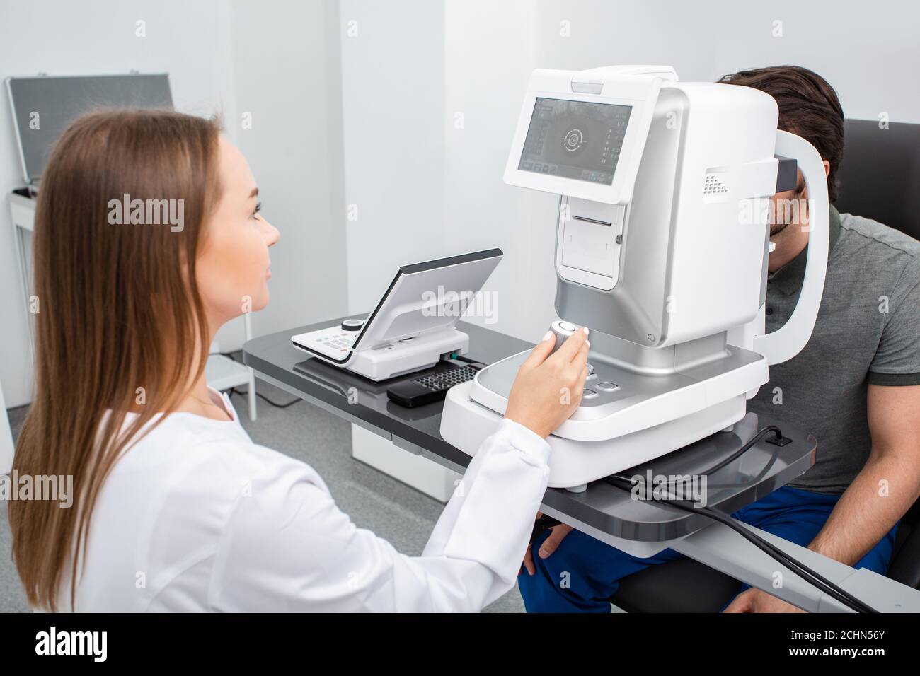 Augenarzt mit Autorefraktor berechnet die Sehkorrektur eines Patienten. Augenuntersuchung und diagnostische Augenerkrankungen Stockfoto