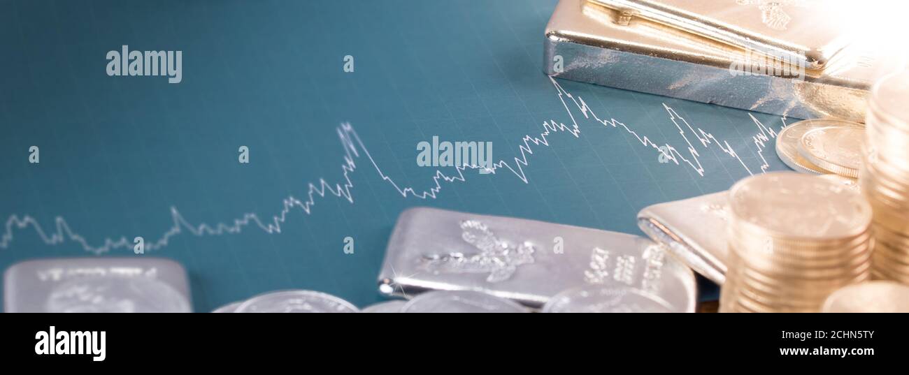 Silber- und Goldbarren und Münzen mit Preistabelle. Investitions-/Marktkonzept Stockfoto