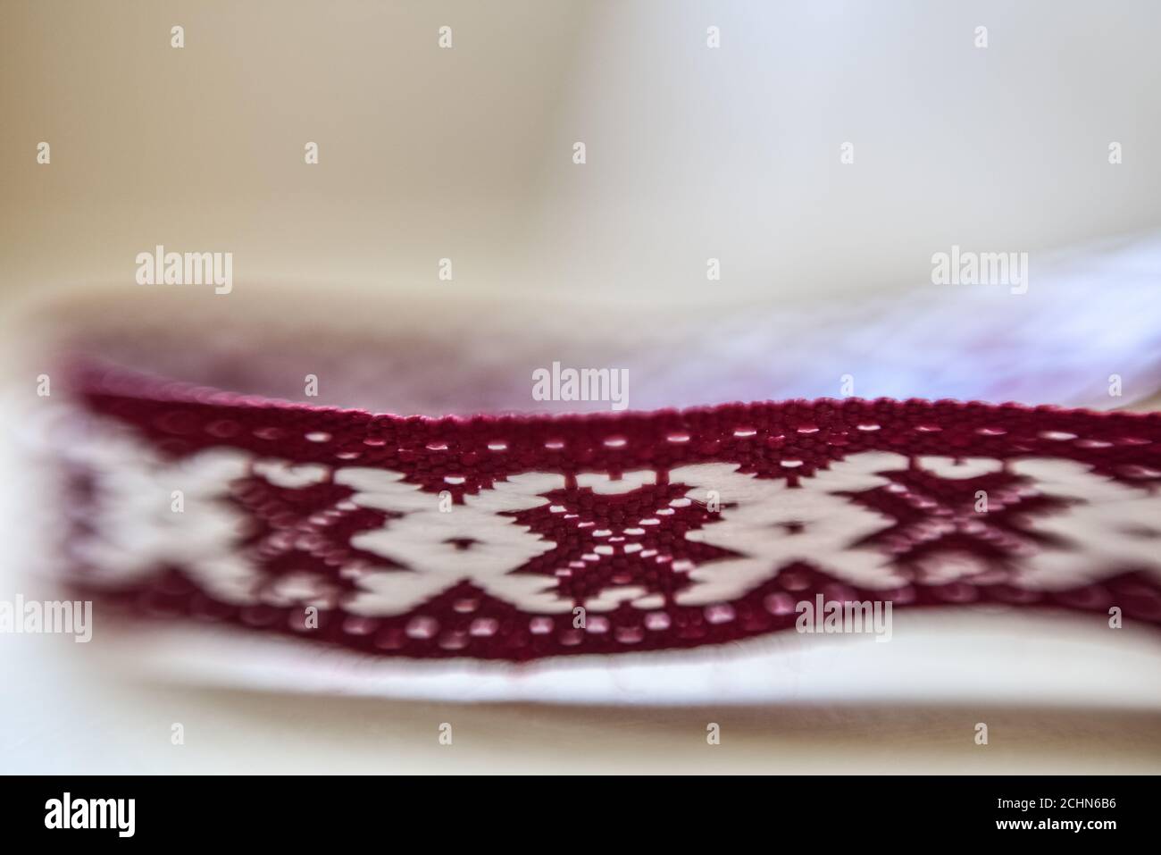 Lettischer Ornamentgürtel auf weißem verschwommenem Hintergrund Stockfoto