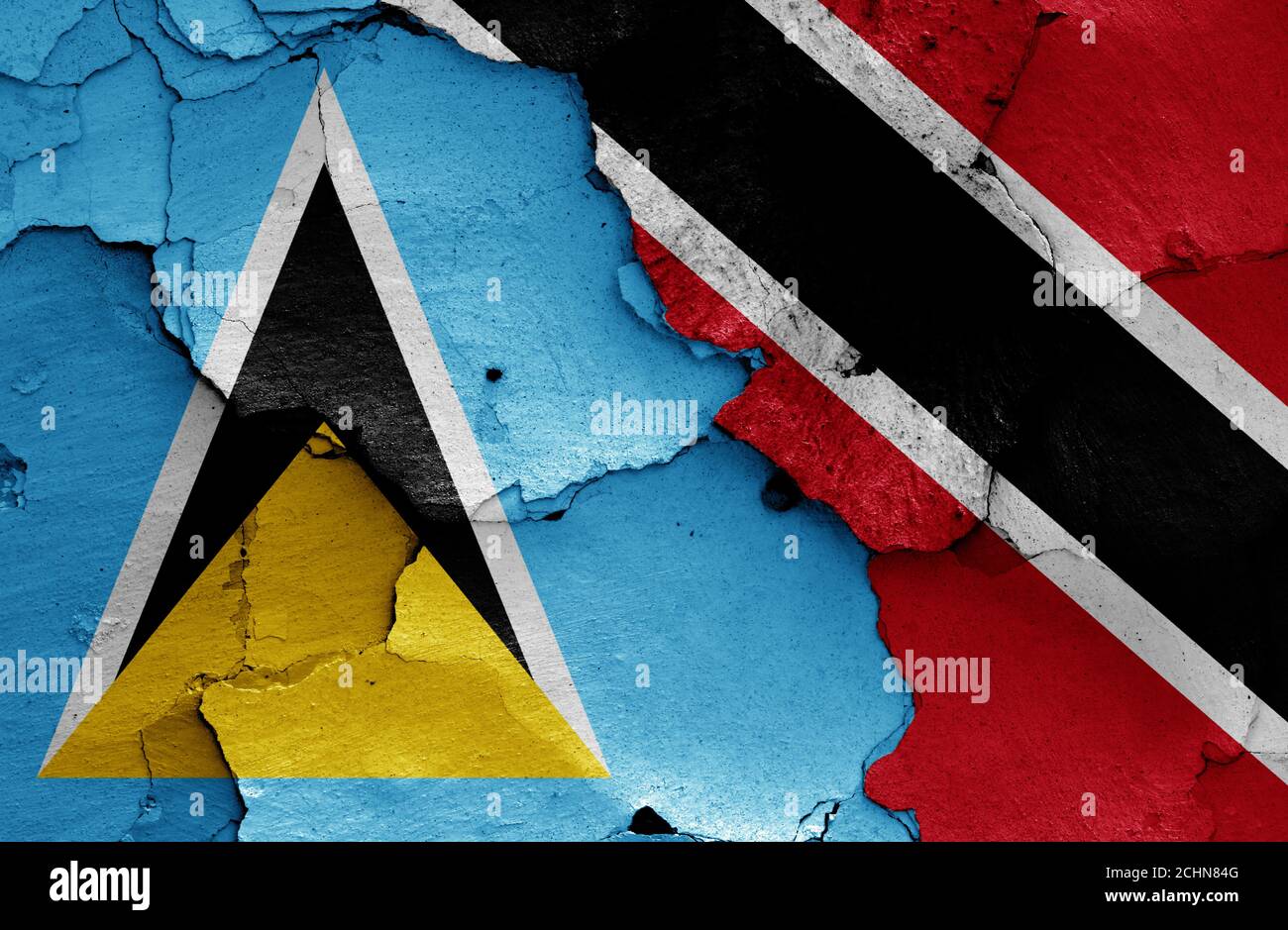 Flaggen von St. Lucia und Trinidad und Tobago bemalt Rissige Wand Stockfoto