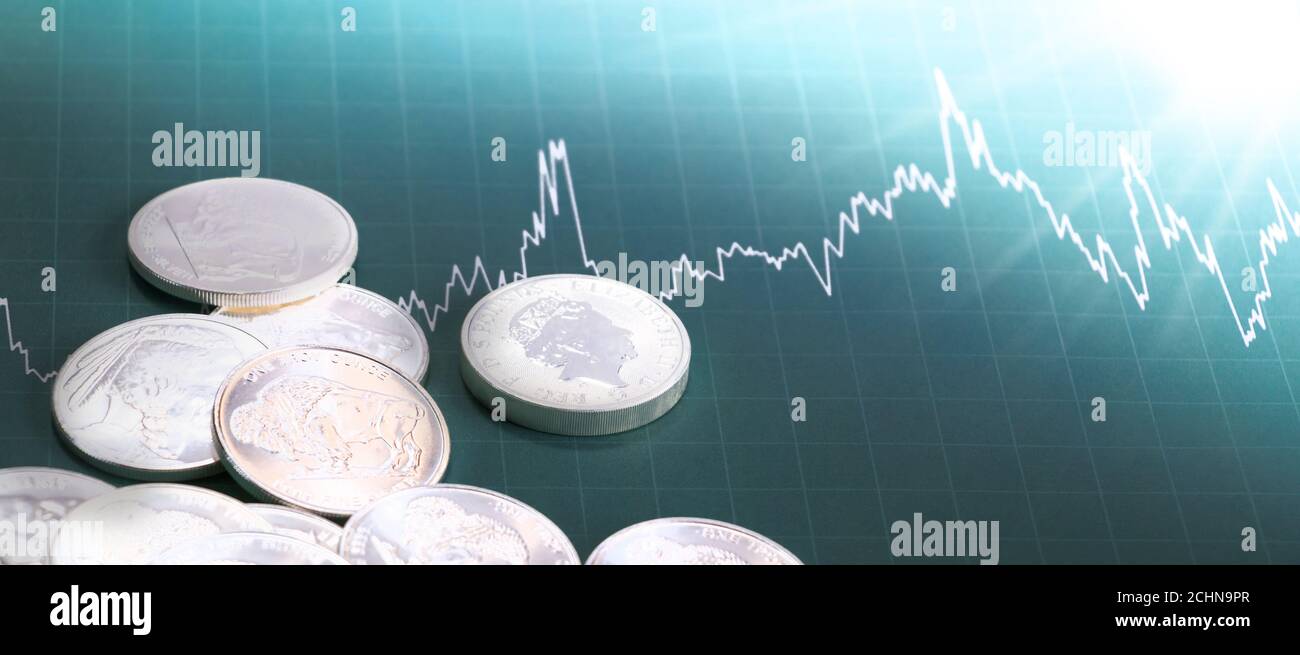 Silbermünzen mit Preistabelle und Sonne scheint. Investitions-/Marktkonzept Stockfoto