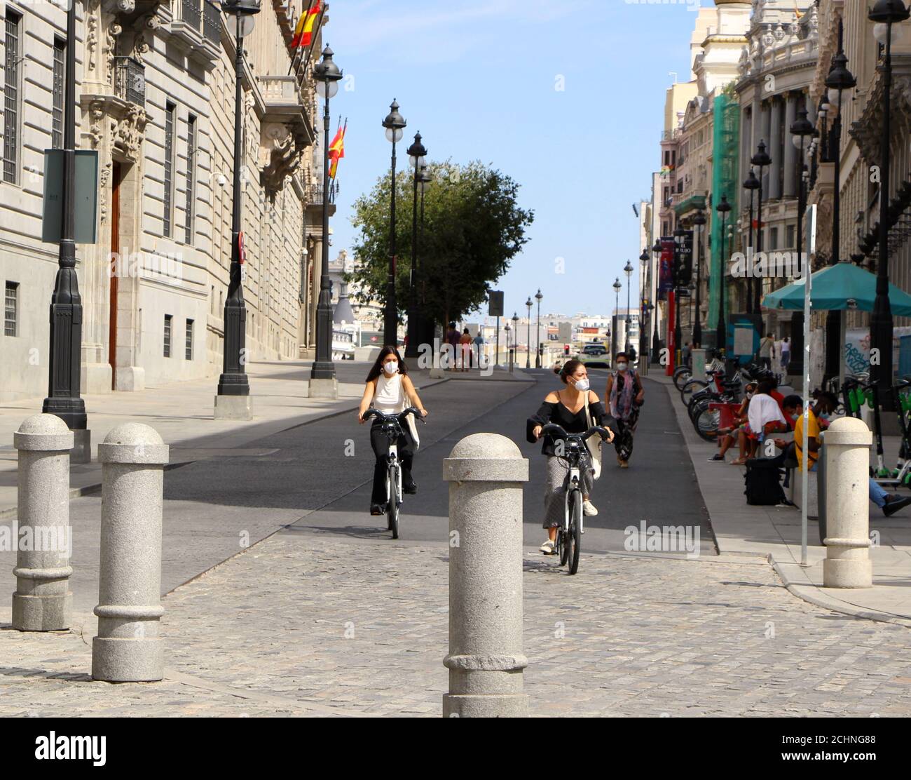 Blick entlang der Calle de Alcala Madrid Spanien von Puerta Del Sol mit zwei Mädchen auf Fahrrädern mit Gesichtsmasken Während der covid-19 Pandemie Stockfoto