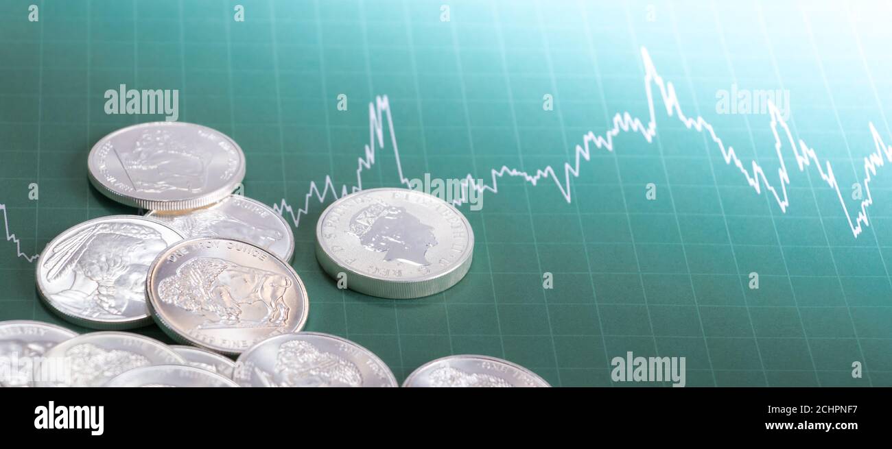 Silbermünzen auf der Preisliste verstreut. Investitions-/Marktkonzept Stockfoto