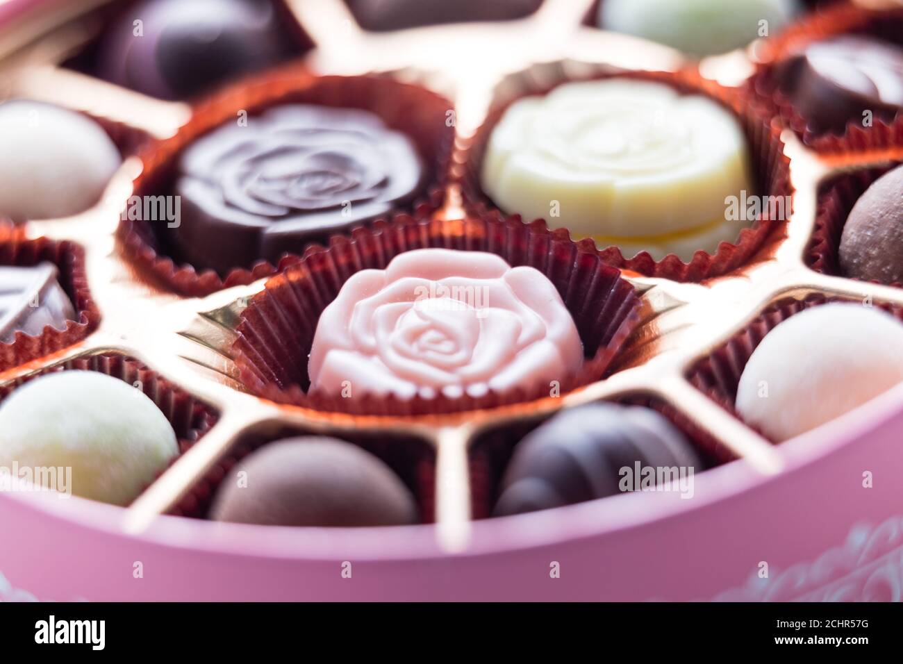 Verschiedene Pralinen in rosa Schachtel, geringe Schärfentiefe Stockfoto