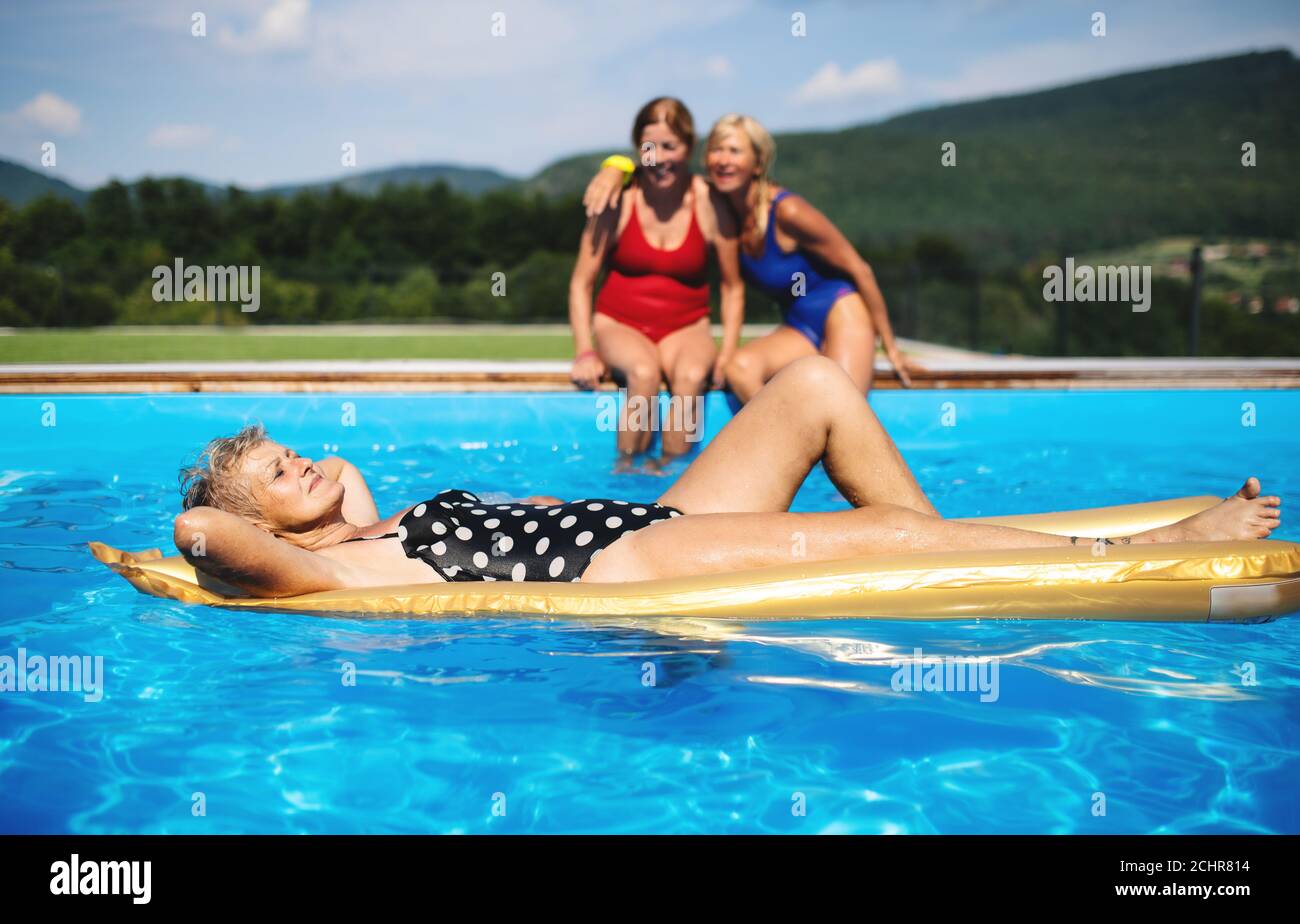 Ältere Frauen im Schwimmbad im Freien im Hinterhof, entspannend. Stockfoto