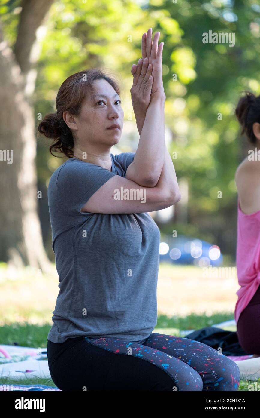 Chinesisch-amerikanische Frauen bei einem Yogakurs im Kissena Park, Flushing, Queens, New York City. Stockfoto
