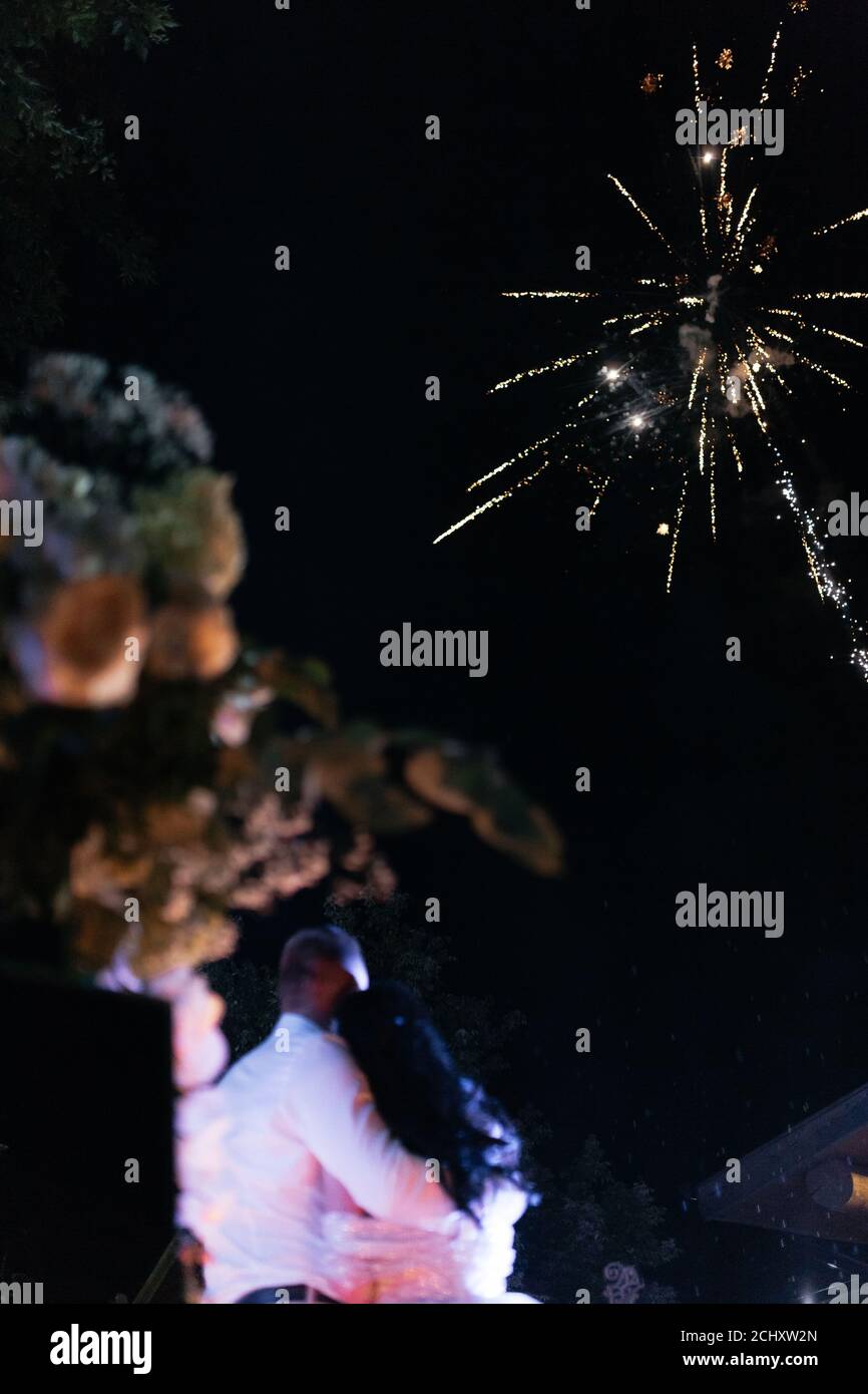 Glückliche Brautpaare beobachten Gruß am Ende ihrer Hochzeit. Hochzeitsgrüße. Anrede. Dunkler Hintergrund Stockfoto