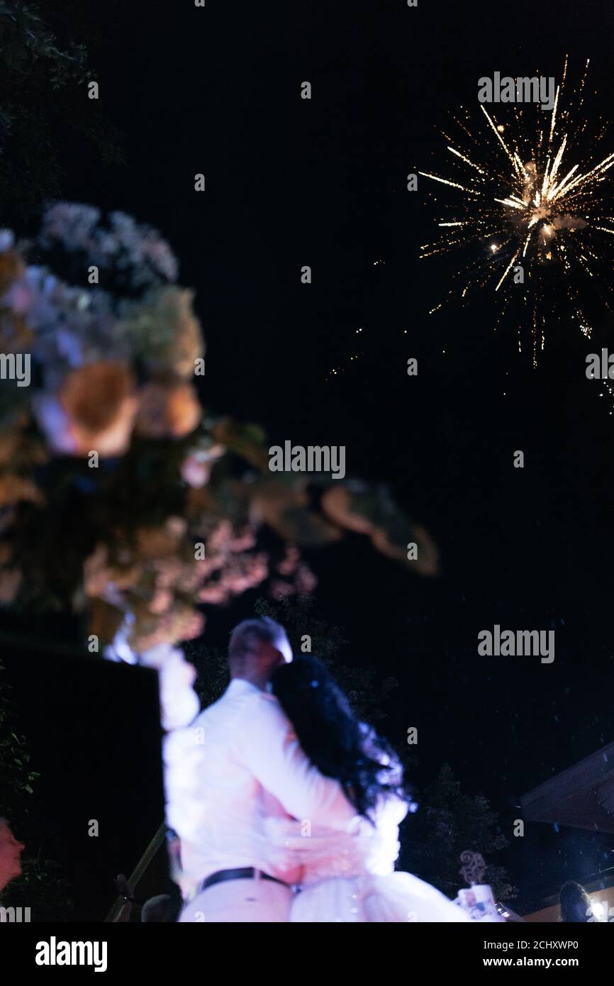 Glückliche Braut und Bräutigam beobachten Gruß am Ende ihrer Hochzeit. Hochzeitsgrüße. Anrede. Dunkler Hintergrund Stockfoto