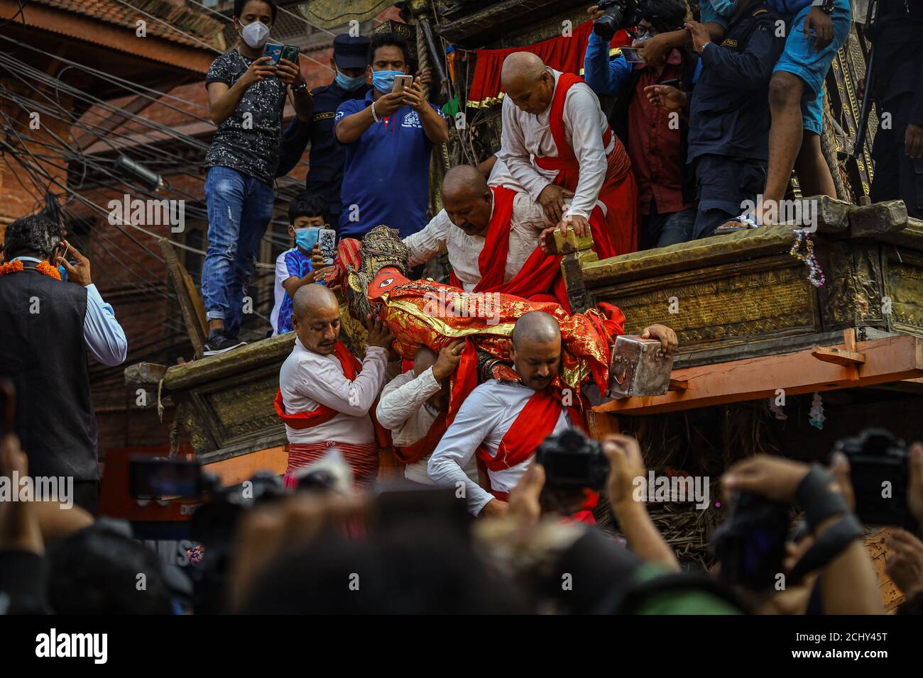 Priester tragen das Idol von Rato Machhindranath, während das Wagenfest von Rato Machhindranath inmitten des Ausbruchs der Coronavirus-Krankheit bei Bungamati endet.die Jahrhunderte alte Prozession sollte Ende April beginnen, wurde aber wegen einer landesweiten Sperre verzögert. Stockfoto