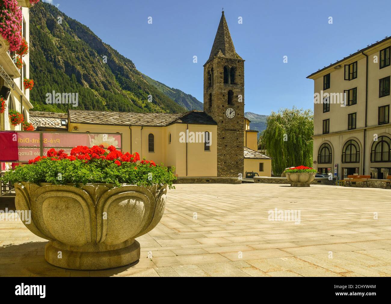 Hauptplatz des alten Alpendorfes mit der Kirche des heiligen Laurentius (15.-19. Jh.) und einem blühenden Geranien-Topf, Pré-Saint-Didier, Aosta, Italien Stockfoto