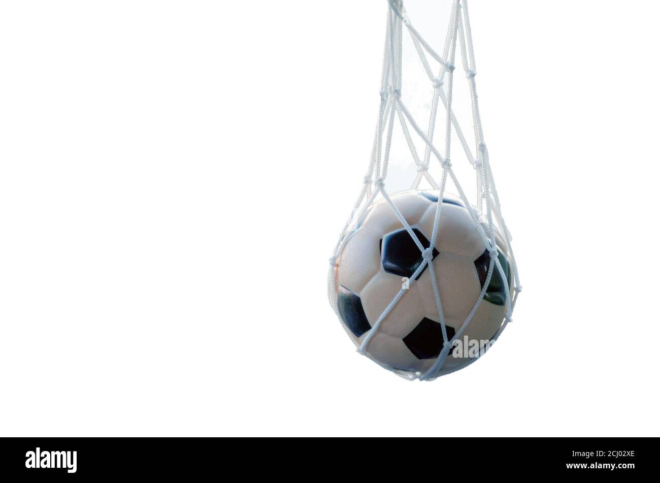 Ein schwarz-weißer Fußball wiegt im Netz, auf einem isolierten weißen Hintergrund Stockfoto