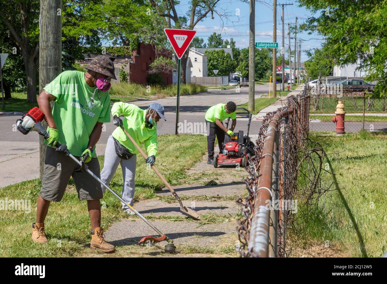 Detroit, Michigan - Arbeiter der Detroit Grounds Crew säubern einen überwucherten Bürgersteig. Stockfoto