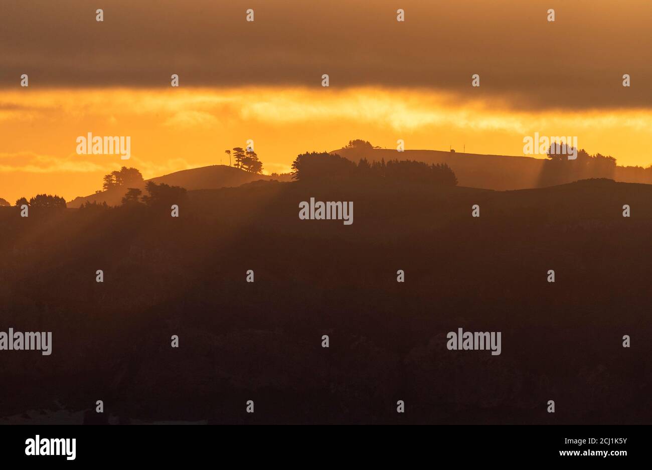 Sonnenuntergang über Küstenbergen in der Nähe von Dunedin, Neuseeland, Südinsel, Dunedin Stockfoto