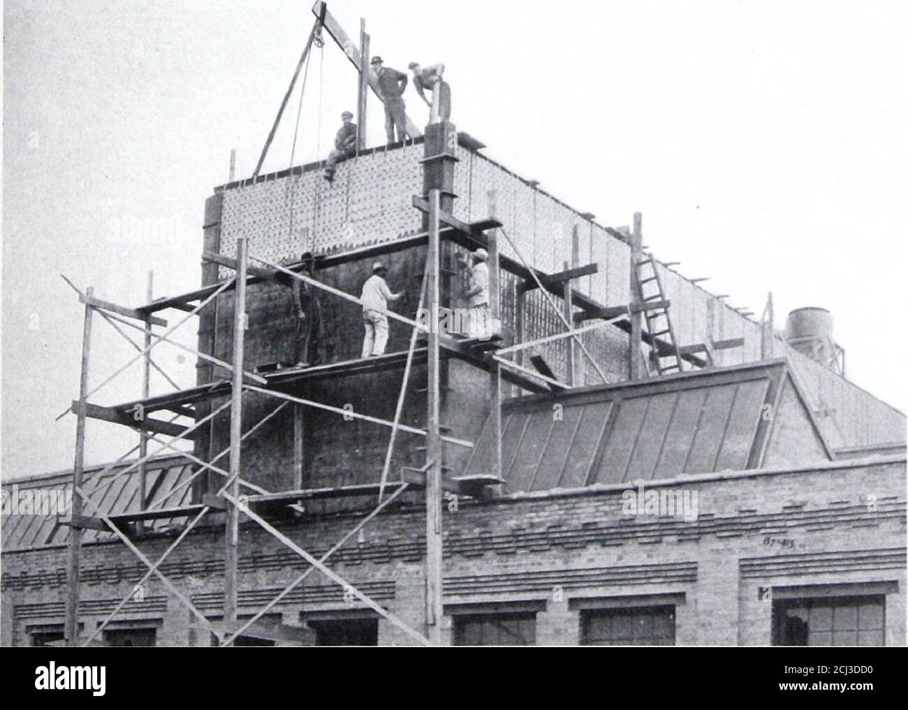 . Asbestosteel für Dächer und Wände. AEMSTROXG CORK COMPANY, BEAVER FALLS, PA. Zeigt den Zementputz, der auf die vertikalen Leistenwände eines Lagerbehälters von Asbestosteel aufgetragen wird Stockfoto