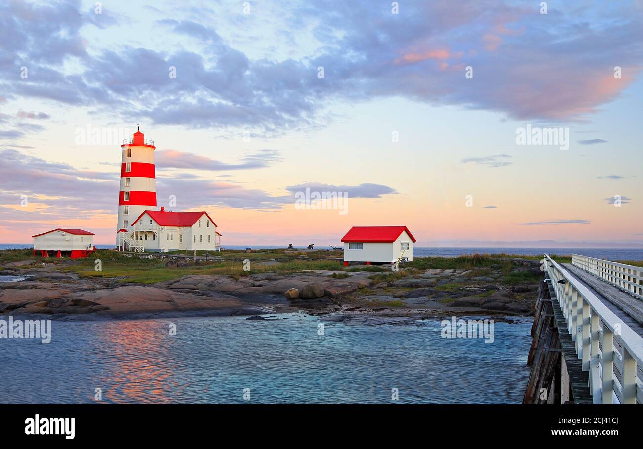 Pointe-des-Monts Leuchtturm bei Sonnenuntergang mit Spiegelungen im Meer, Cote-Nord, Quebec Stockfoto Pointe-des-Monts Leuchtturm bei Sonnenuntergang mit Spiegelungen im Meer, Cote-Nord, Quebec Stockfoto