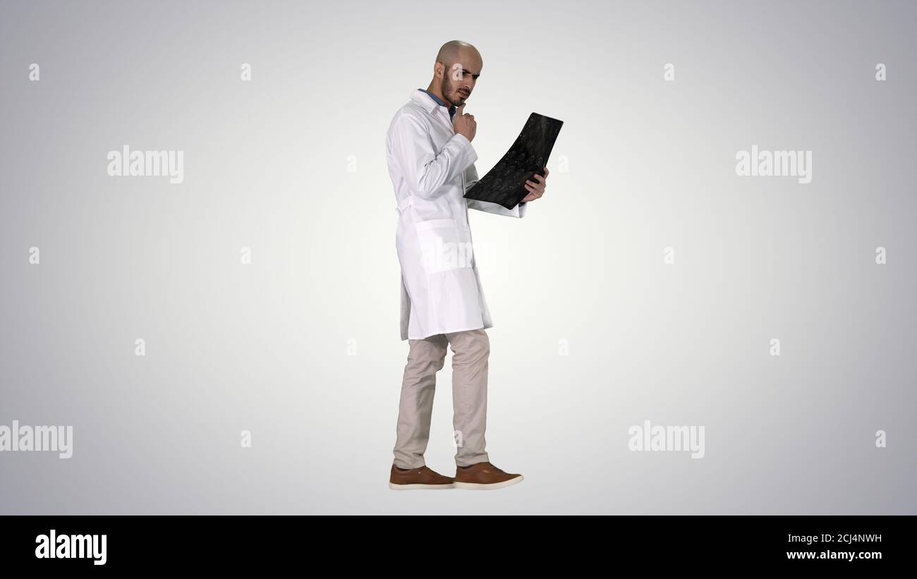 Junger männlicher Arzt, der einen MRT-Hirnscan liest und überprüft Wil Stockfoto