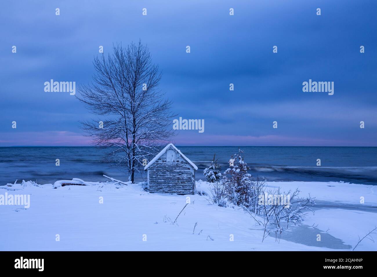 An einem Winterabend am Lake Michigan, nahe Escanaba, Michigan, USA, wird der Himmel vorüber Stockfoto