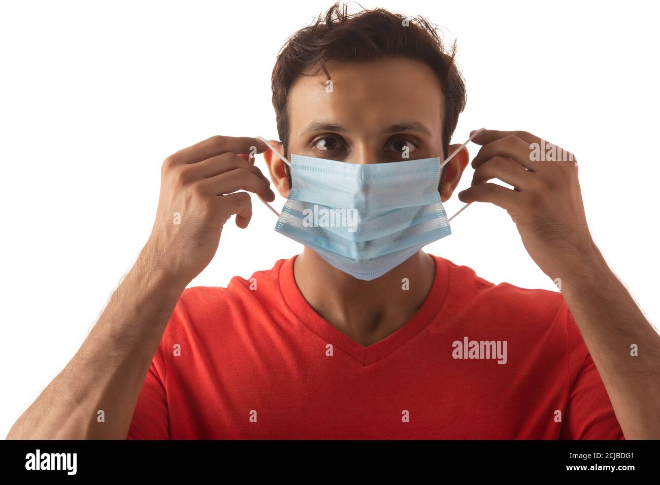Junger Mann schützt sich vor verschiedenen Infektionen durch das Tragen einer Maske Stockfoto