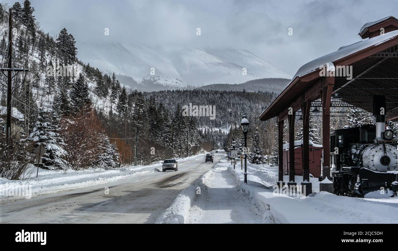 Winterliche Straße in den felsigen Bergen mit Dampflokomotive Stockfoto