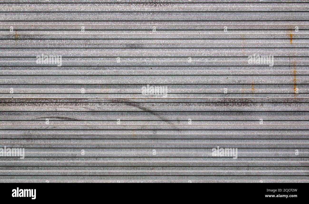 Hintergrund aus verzinktem Wellblech mit Spuren von Rost und horizontaler Ausrichtung. Stockfoto