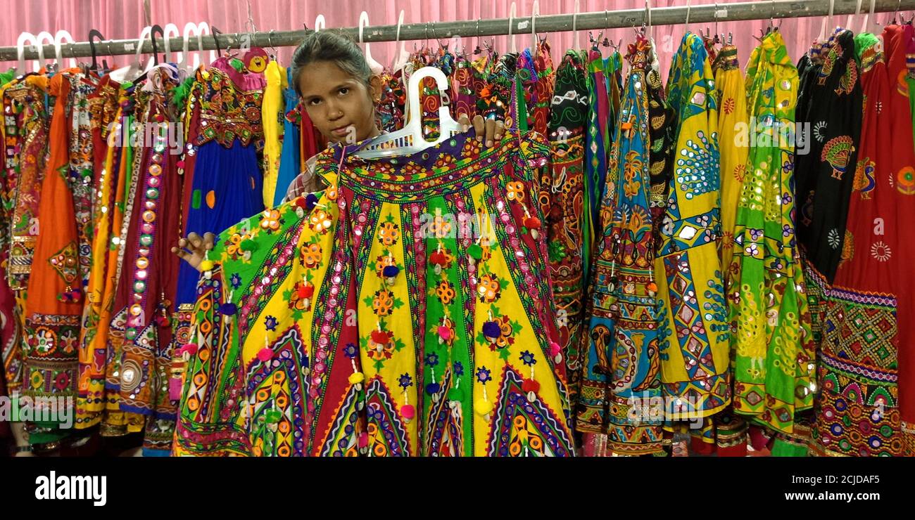 DISTRIKT KATNI, INDIEN - 22. SEPTEMBER 2019: Ein asiatisches Verkaufsmädchen, das Frauen bei der lokalen Stadtschau mit niederen Kleidungsstücken in den traditionellen Bekleidungsladen einführt Stockfoto